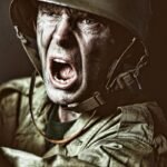 Close-up of a soldier in camouflage shouting during a military action scene.
