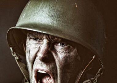 Close-up of a soldier in camouflage shouting during a military action scene.