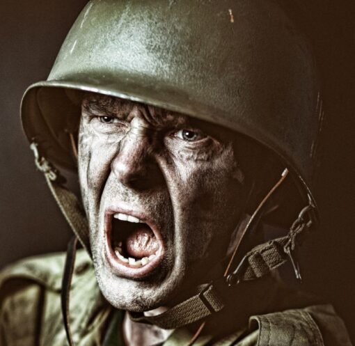 Close-up of a soldier in camouflage shouting during a military action scene.