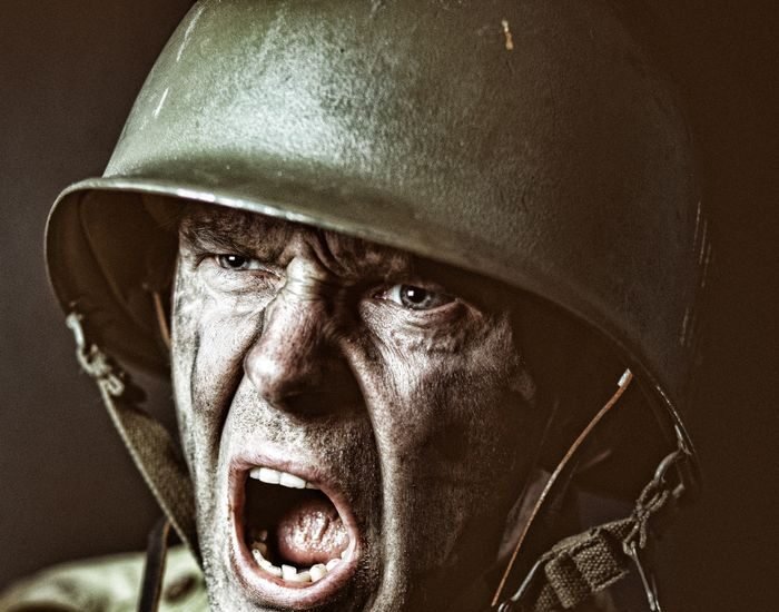 Close-up of a soldier in camouflage shouting during a military action scene.