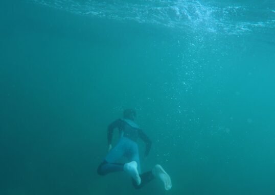 Explore underwater scenes of a snorkeler in a vibrant turquoise ocean, capturing the thrill of diving.