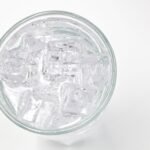 A top view of a glass filled with ice cubes and water, offering a refreshing feel.