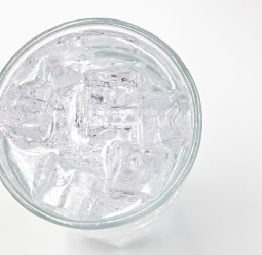 A top view of a glass filled with ice cubes and water, offering a refreshing feel.