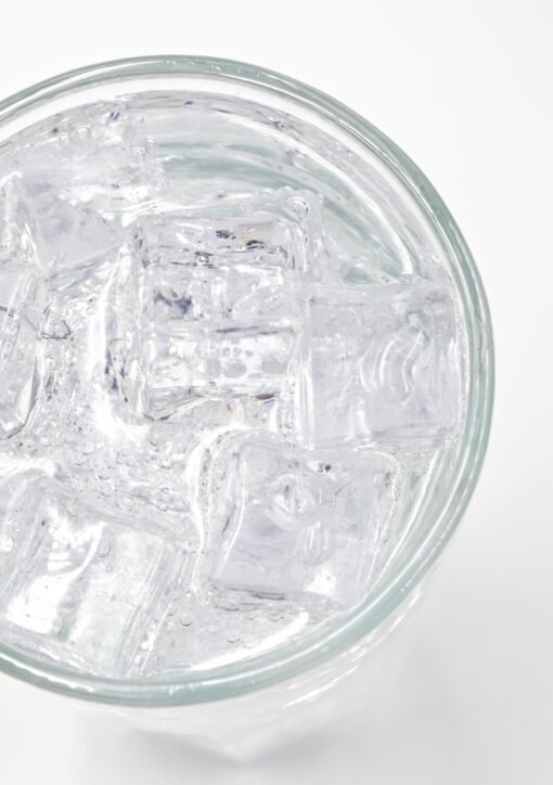 A top view of a glass filled with ice cubes and water, offering a refreshing feel.