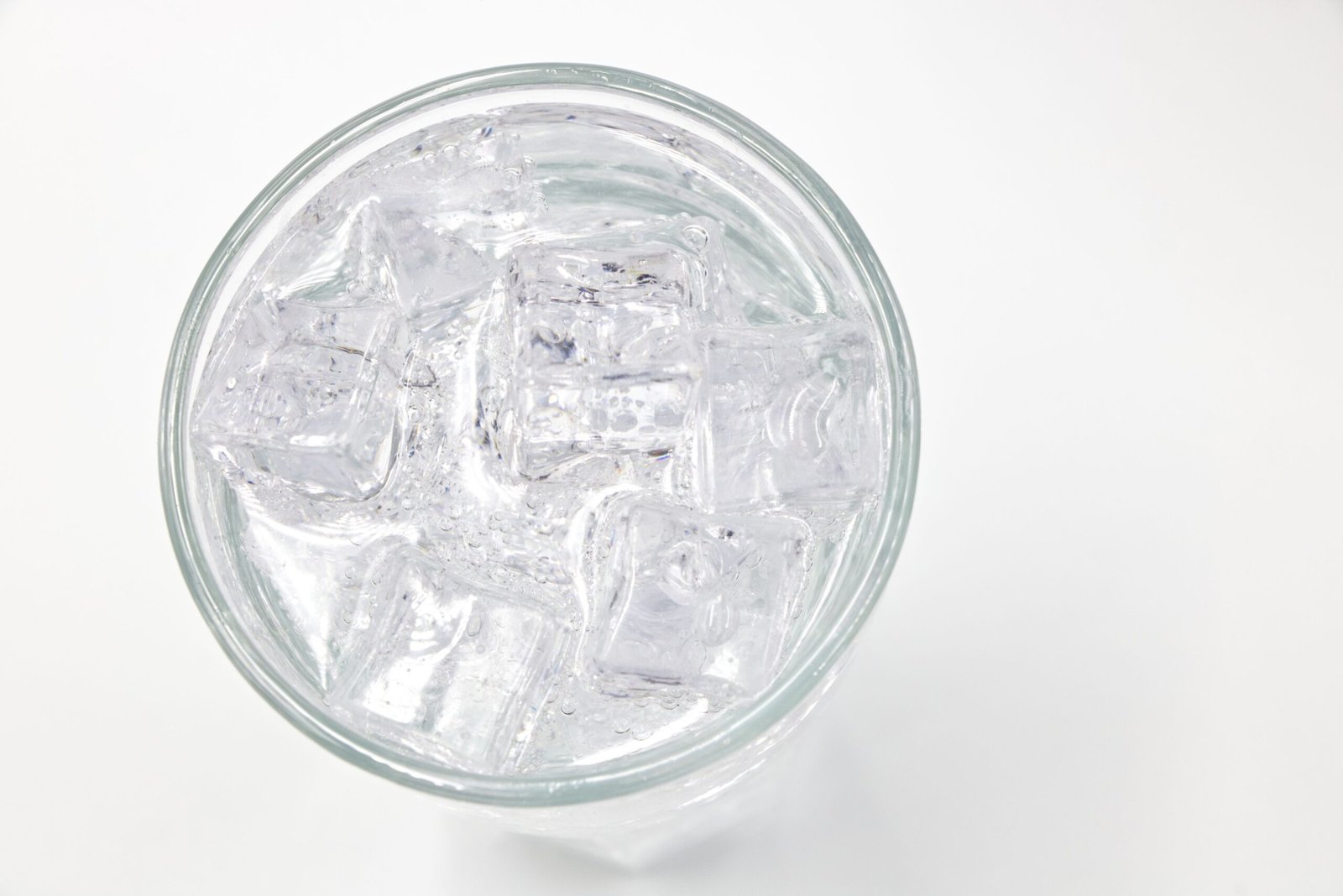 A top view of a glass filled with ice cubes and water, offering a refreshing feel.