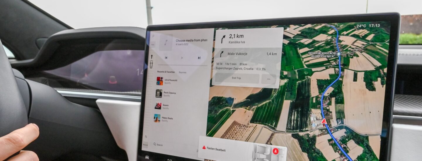 Inside view of a car with a large navigation screen and detailed digital map.