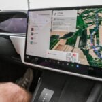 Inside view of a car with a large navigation screen and detailed digital map.