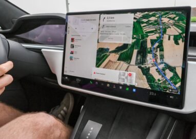 Inside view of a car with a large navigation screen and detailed digital map.