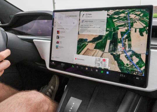 Inside view of a car with a large navigation screen and detailed digital map.