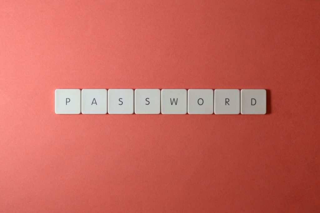 Focus on password security with white keyboard tiles spelling 'PASSWORD' on a coral background.