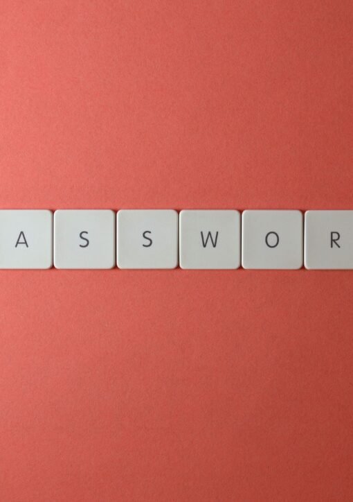 Focus on password security with white keyboard tiles spelling 'PASSWORD' on a coral background.