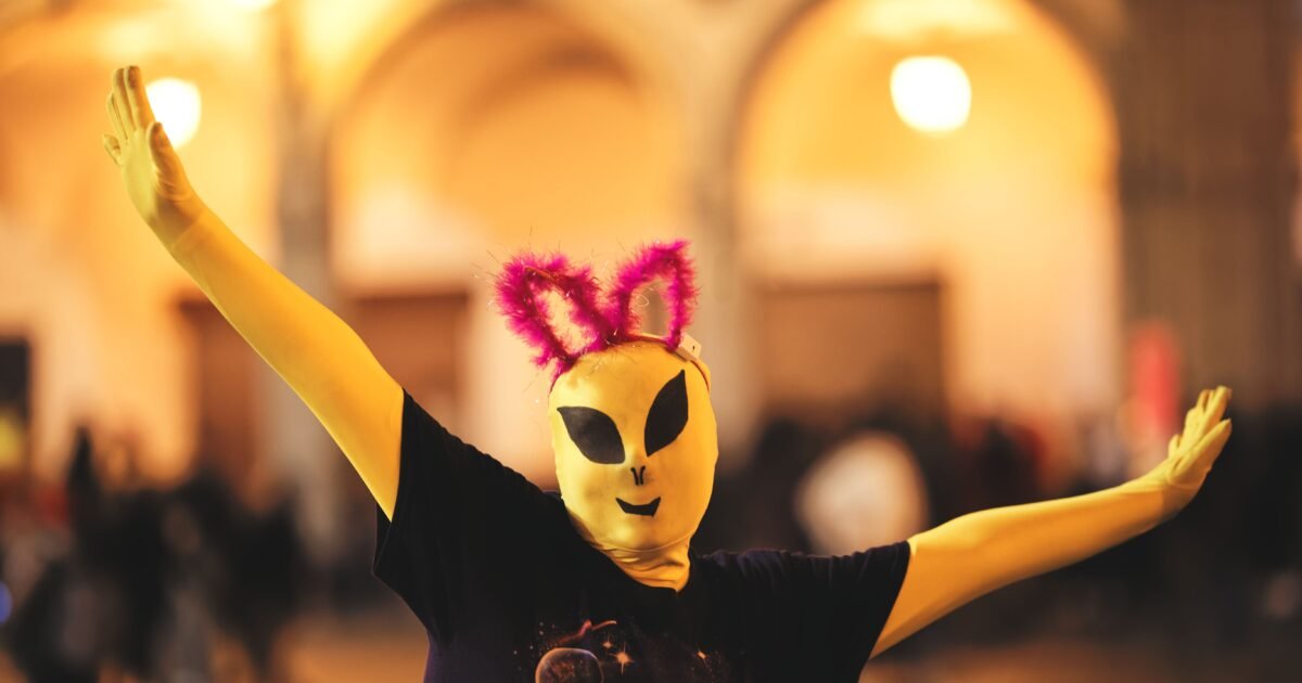Person in alien costume with quirky ears during a lively Arequipa celebration.