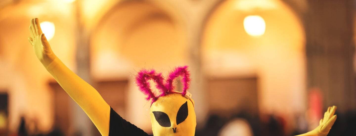 Person in alien costume with quirky ears during a lively Arequipa celebration.