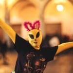 Person in alien costume with quirky ears during a lively Arequipa celebration.