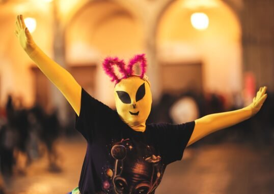 Person in alien costume with quirky ears during a lively Arequipa celebration.