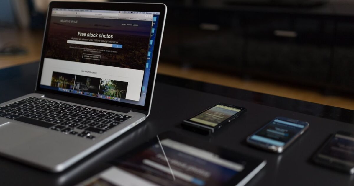 A contemporary workspace showcasing a laptop, tablet, and smartphones, ideal for tech and freelance use.