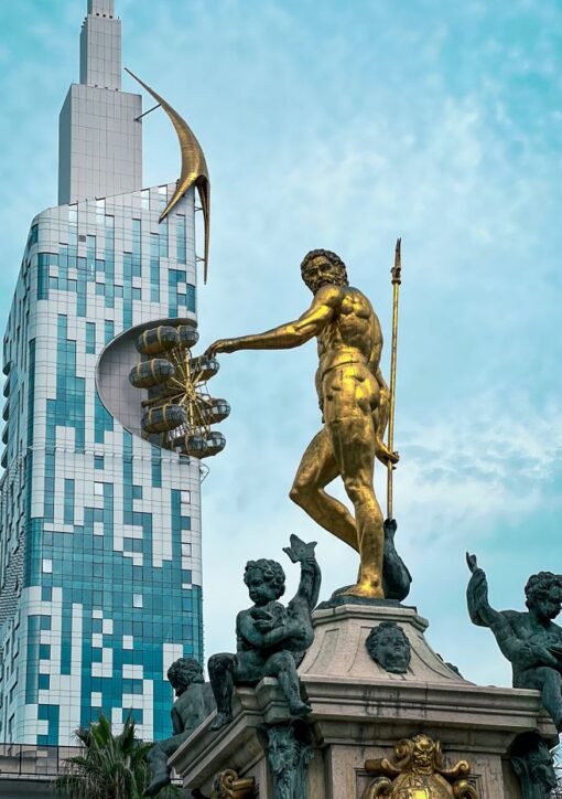 Iconic golden statue with modern skyscraper in Batumi, Georgia's vibrant cityscape.