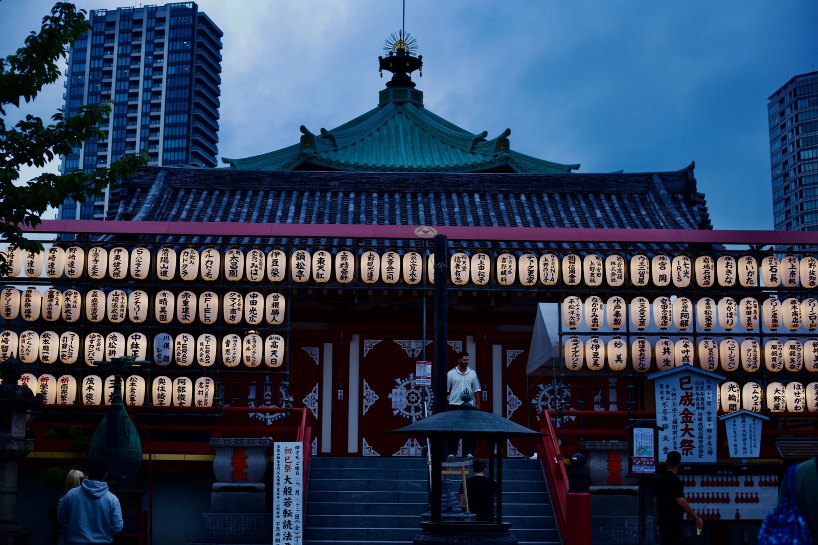 A serene view of a Japanese temple adorned with lanterns during twilight.
