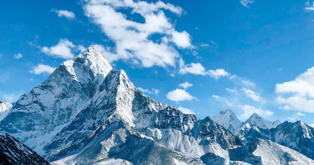 A stunning view of a snow-capped mountain peak under a clear blue sky, showcasing nature's beauty.