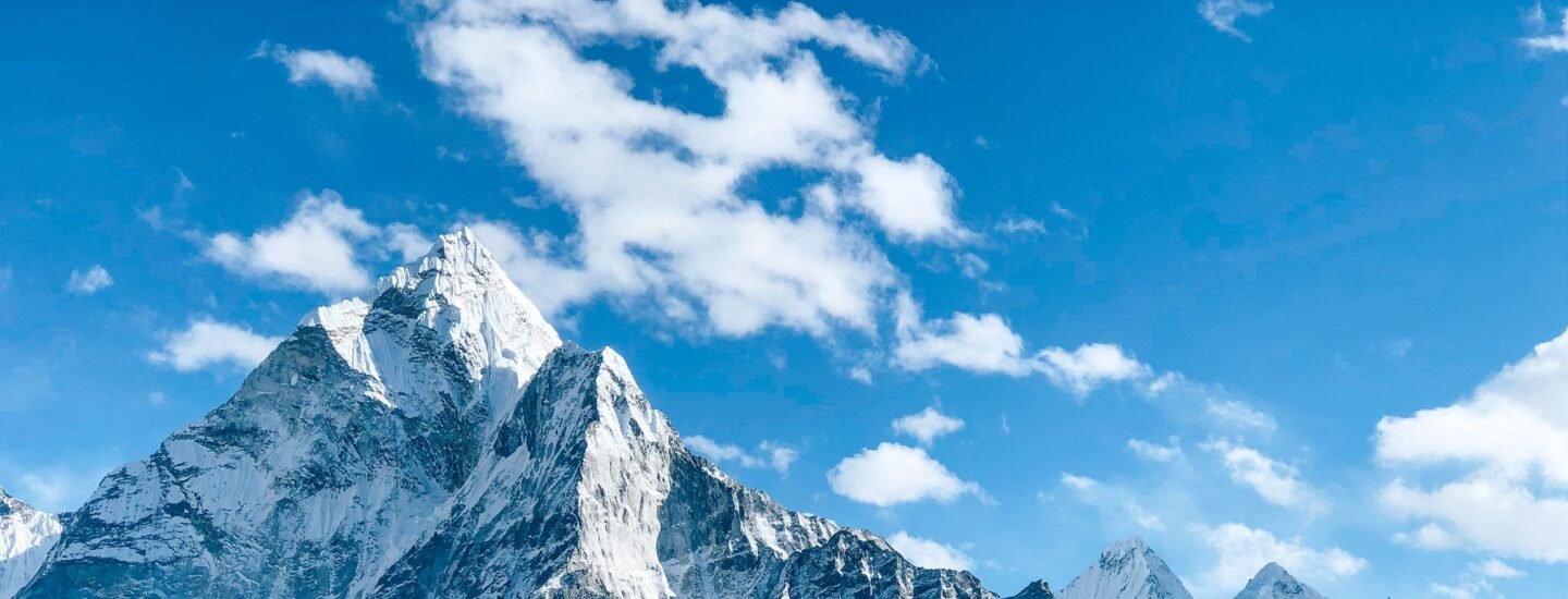 A stunning view of a snow-capped mountain peak under a clear blue sky, showcasing nature's beauty.