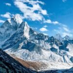 A stunning view of a snow-capped mountain peak under a clear blue sky, showcasing nature's beauty.