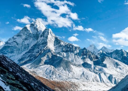 A stunning view of a snow-capped mountain peak under a clear blue sky, showcasing nature's beauty.