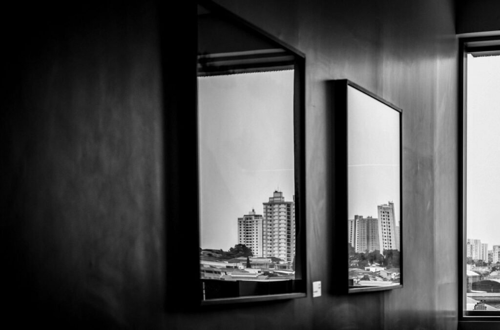 Cityscape reflections captured through indoor mirrors in this monochrome photograph.