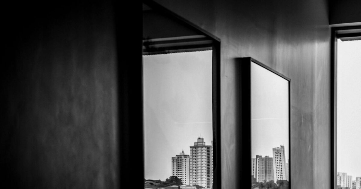 Cityscape reflections captured through indoor mirrors in this monochrome photograph.