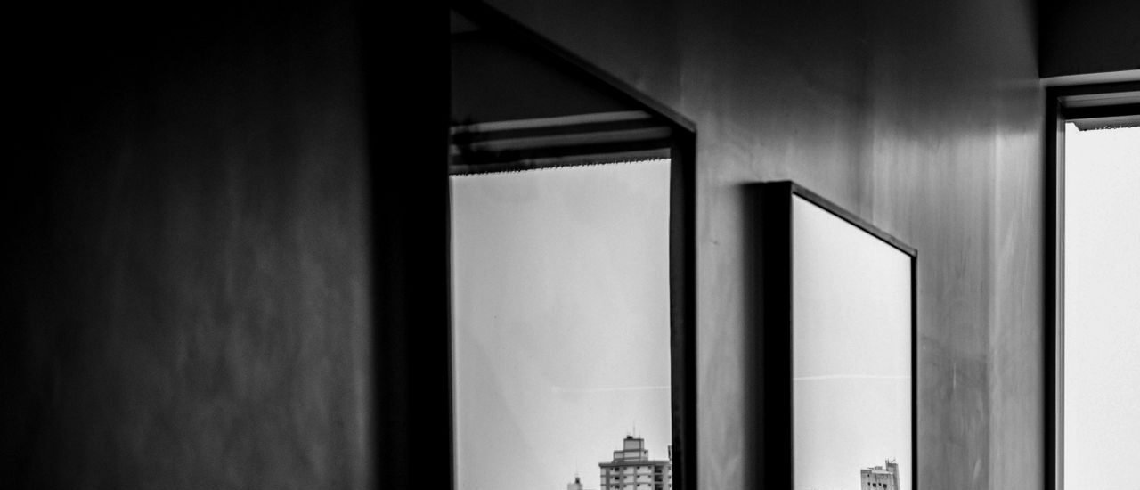 Cityscape reflections captured through indoor mirrors in this monochrome photograph.