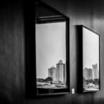 Cityscape reflections captured through indoor mirrors in this monochrome photograph.