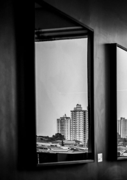 Cityscape reflections captured through indoor mirrors in this monochrome photograph.