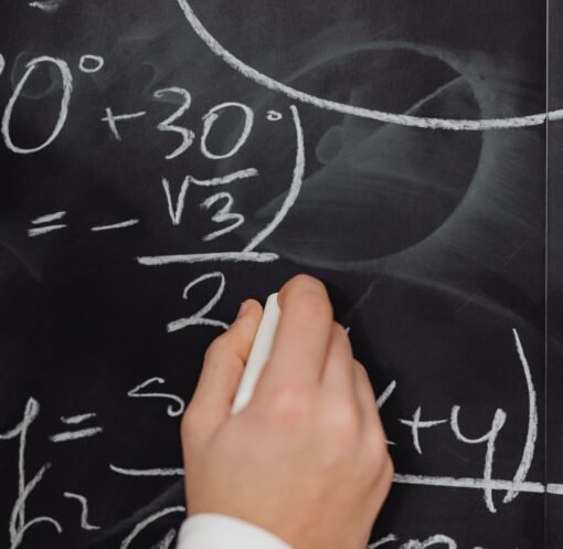 A hand vividly writing complex mathematical equations on a chalkboard.