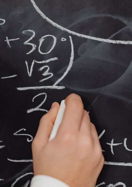 A hand vividly writing complex mathematical equations on a chalkboard.