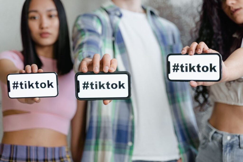 Young adults holding smartphones with TikTok hashtag, showcasing social media engagement.