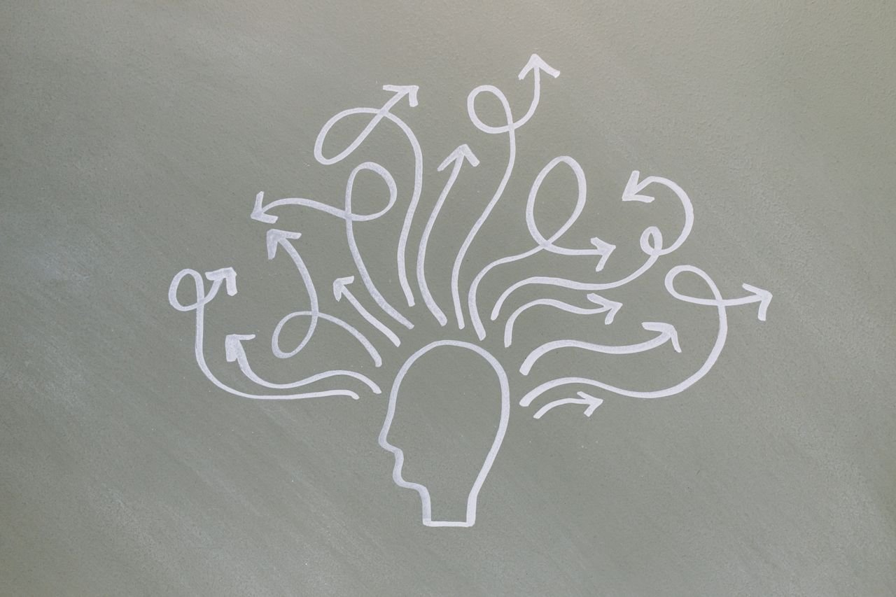 Conceptual chalk drawing illustrating mental health challenges with arrows representing thoughts.