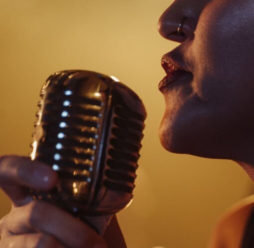 Dynamic close-up of a female singer holding a vintage microphone during a live performance.