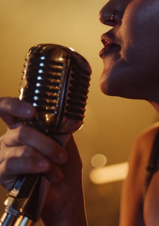 Dynamic close-up of a female singer holding a vintage microphone during a live performance.