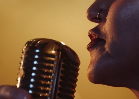 Dynamic close-up of a female singer holding a vintage microphone during a live performance.