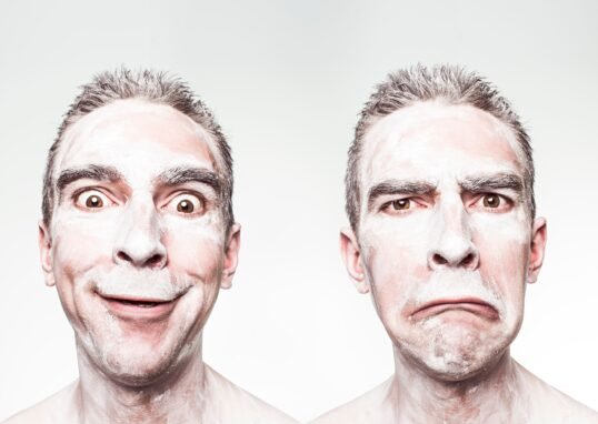A whimsical portrait showing dual expressions of a man with a painted face.