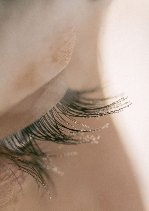 A detailed close-up capturing frost delicately settled on human eyelashes, illustrating the cold beauty of winter.