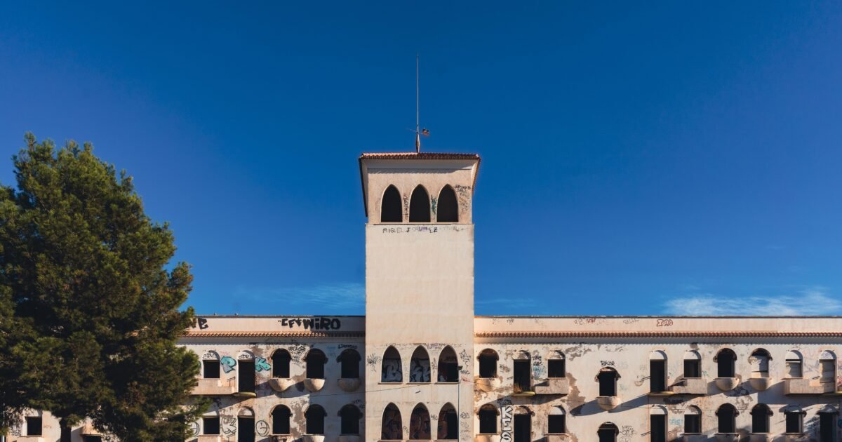 An abandoned building with graffiti under a clear blue sky in San Javier, Spain.