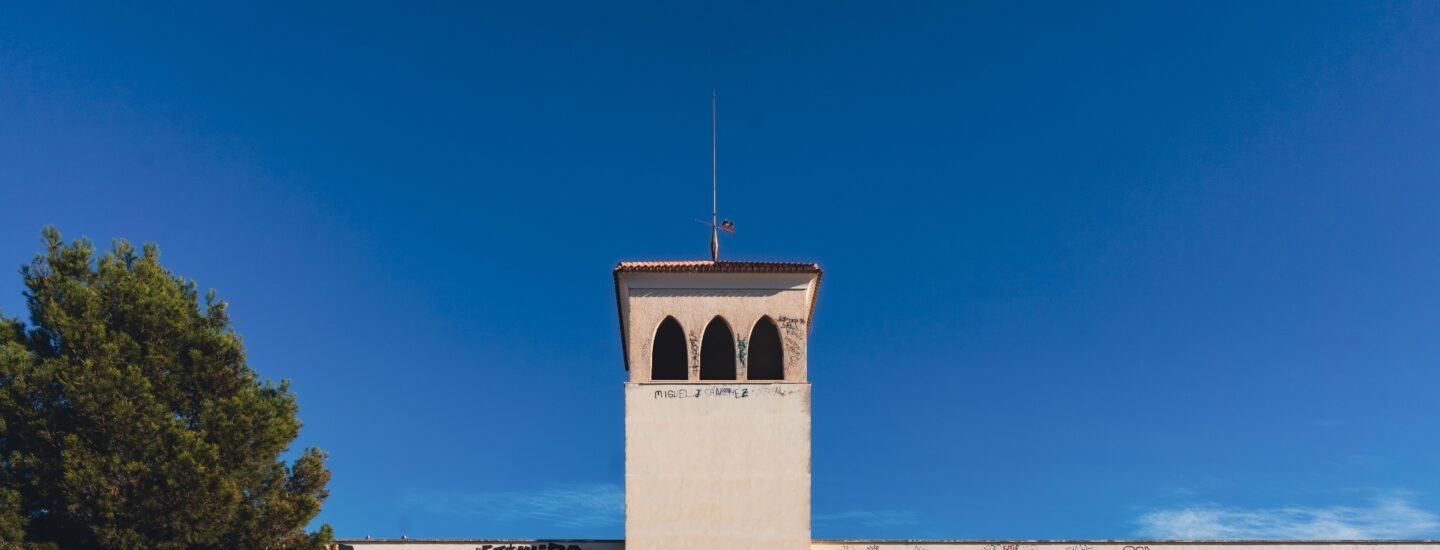 An abandoned building with graffiti under a clear blue sky in San Javier, Spain.