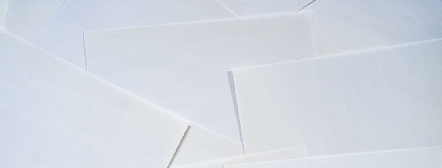 Abstract image featuring overlapping sheets of white paper creating geometric textures.