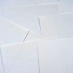Abstract image featuring overlapping sheets of white paper creating geometric textures.