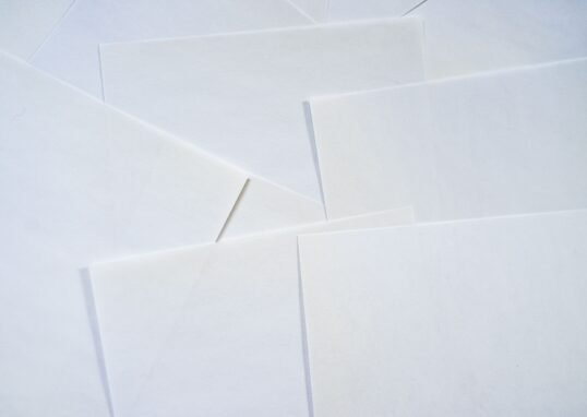 Abstract image featuring overlapping sheets of white paper creating geometric textures.