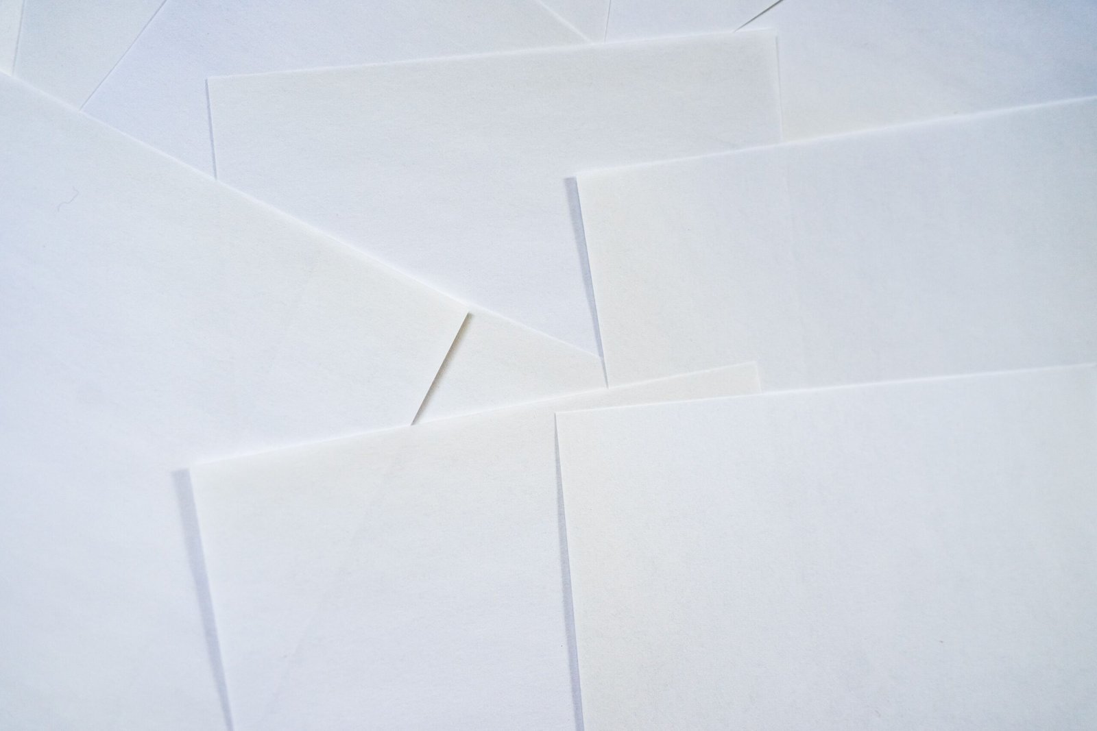 Abstract image featuring overlapping sheets of white paper creating geometric textures.