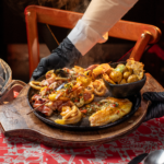 A delectable seafood platter featuring various delicacies served hot in a cozy restaurant setting.