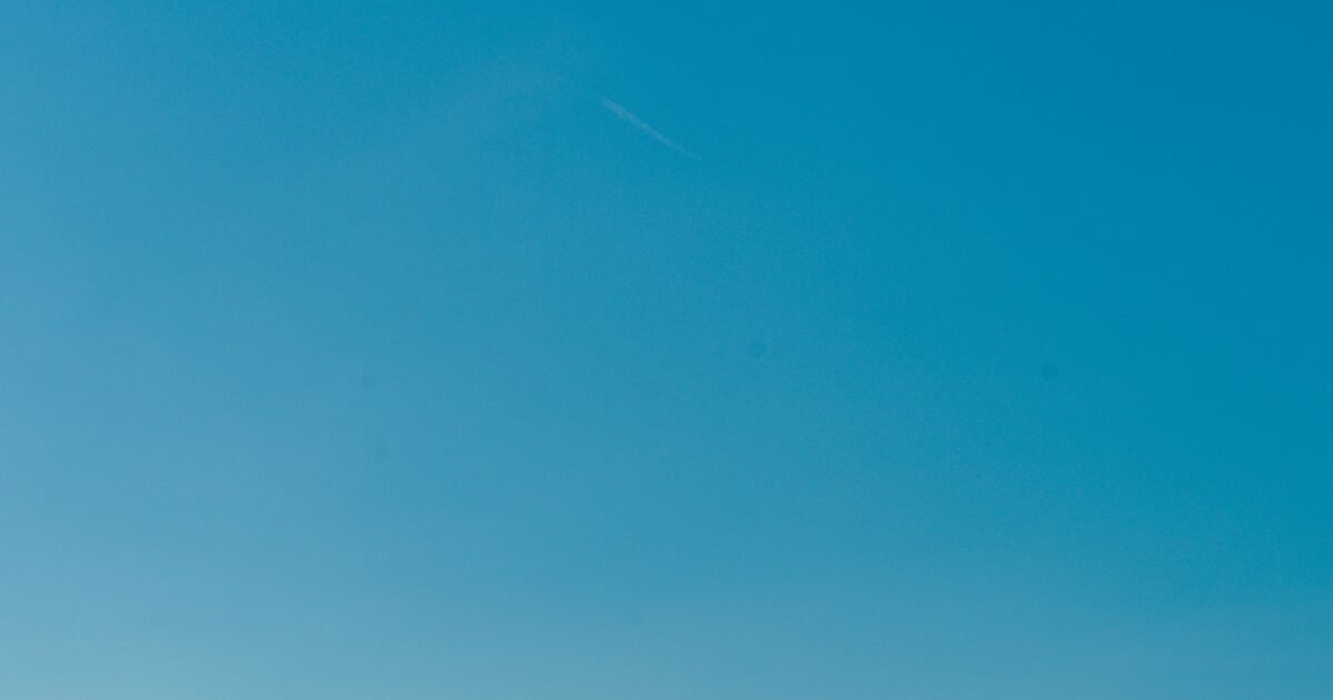 Calm blue waters of the Mediterranean Sea with a clear sky, captured near the Balearic Islands, Spain.