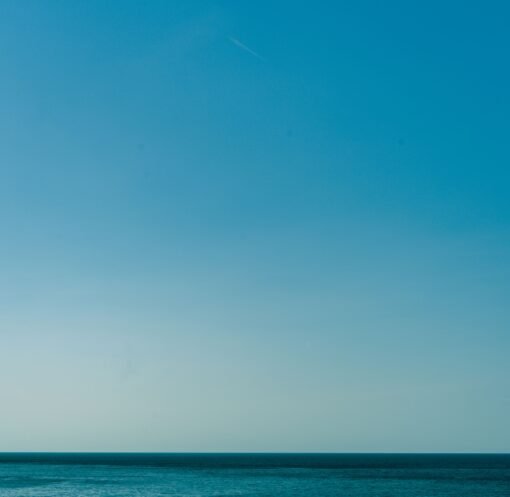 Calm blue waters of the Mediterranean Sea with a clear sky, captured near the Balearic Islands, Spain.