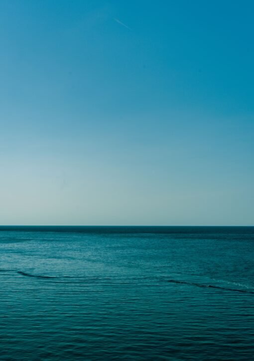 Calm blue waters of the Mediterranean Sea with a clear sky, captured near the Balearic Islands, Spain.